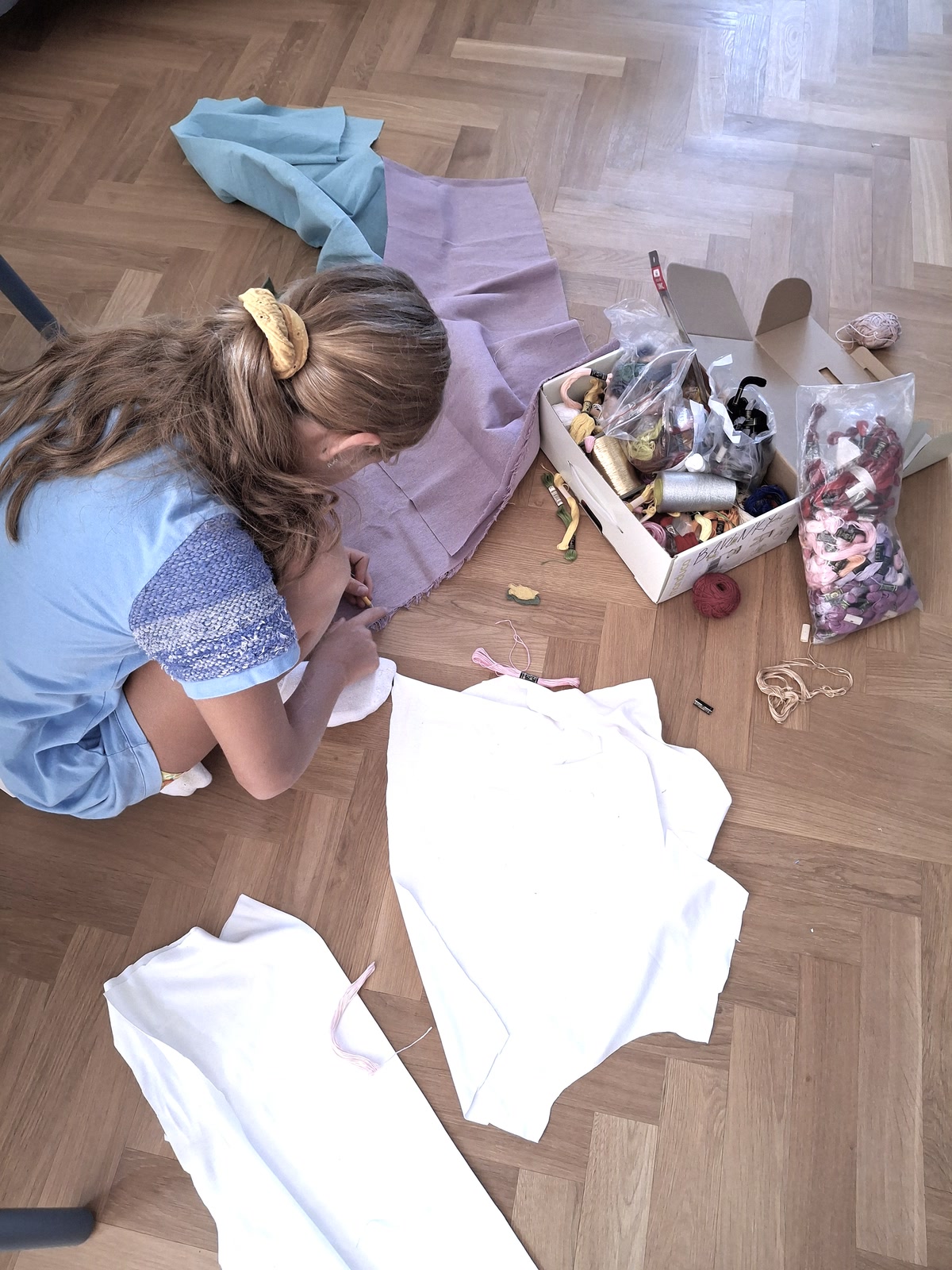 Dieťa strihá a skladá textilné diely počas tvorivej dielne